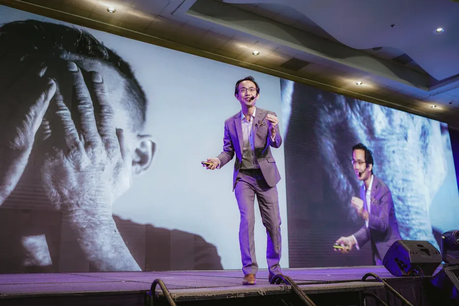 Kenneth Kwan mid-keynote on a large conference stage